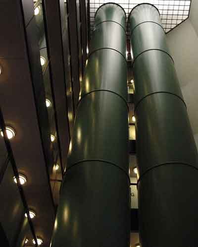 The two tubular elevators in the stairwell.
